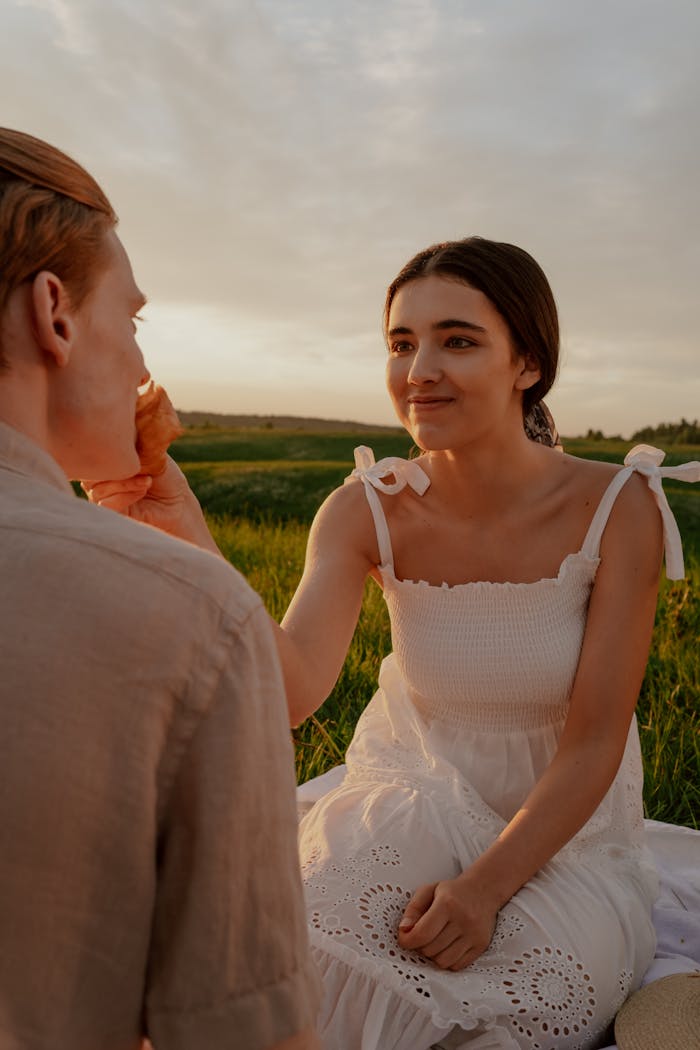 Woman in White Dress Feeding Man